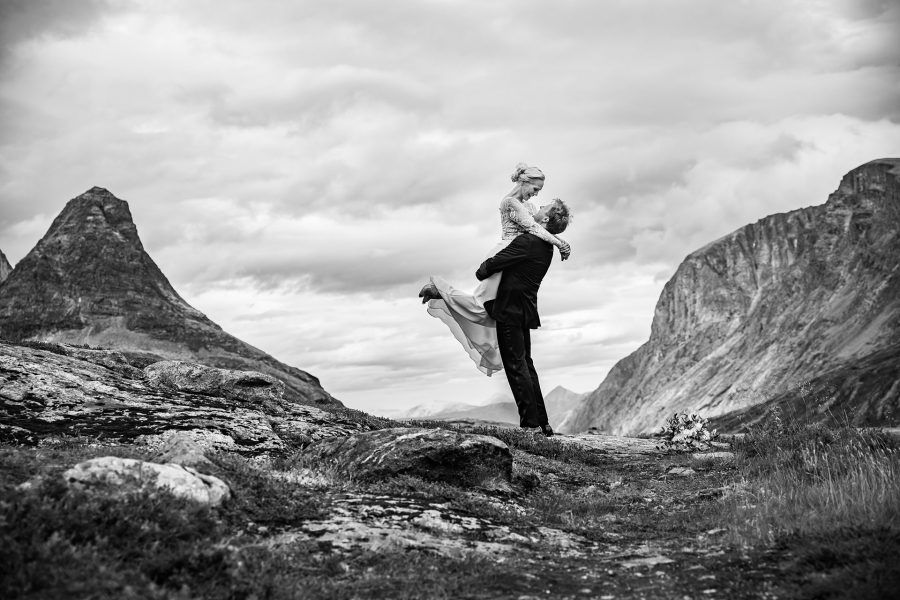 Brudepar omgitt av fjell og natur på Trollstigen
